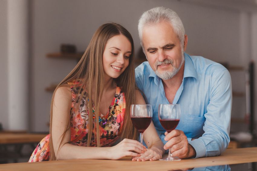 Mujer joven con hombre bebiendo vino